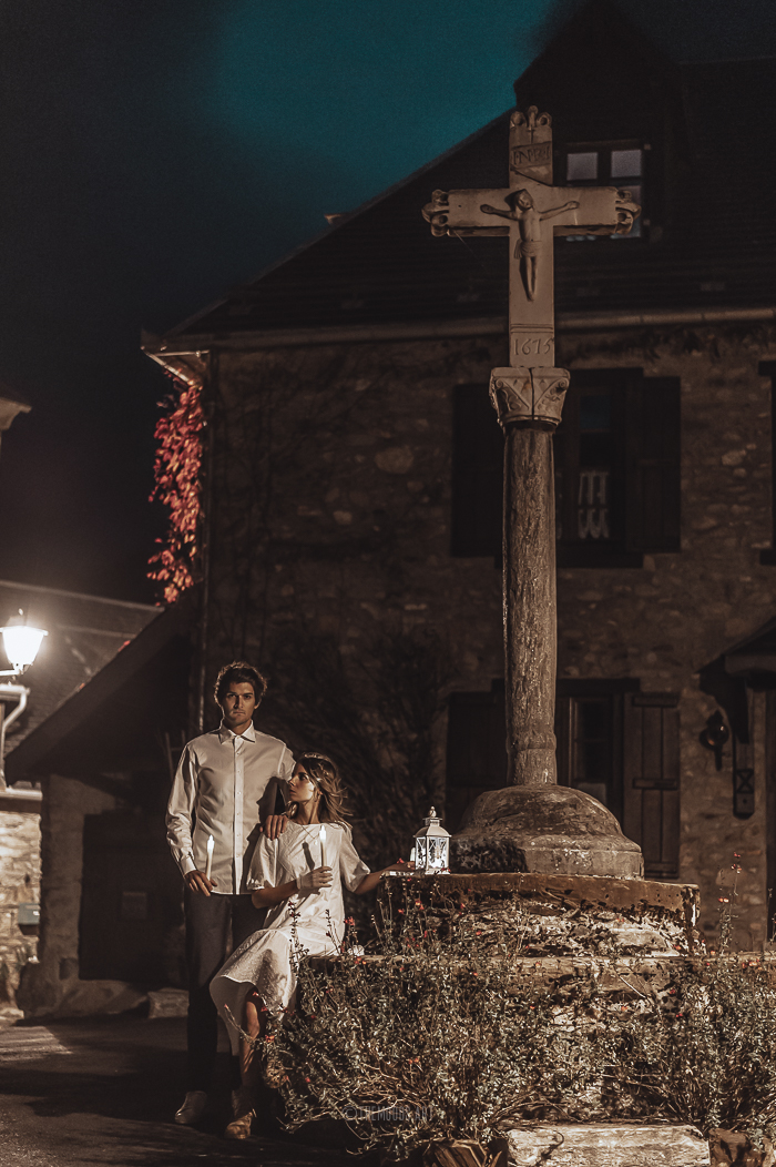 Photographie d'une couple creepy dans un village au clair de lune le soir d'Halloween.