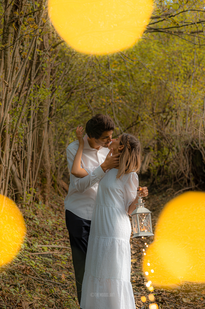 Photographie d'un couple avec un effet de bokeh dans une forêt à la montagne..