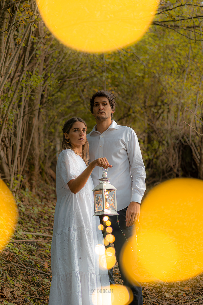 Photographie d'un couple avec un effet de bokeh dans la forêt pendant Halloween.